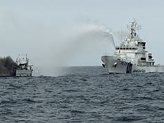 基隆籍漁船「全漁6號」（左）16日清晨在釣魚台東北方約77浬海域失火沉沒，6名菲律賓船員跳海獲救，目前台灣籍張姓船長仍失聯。圖為日本巡視船（右）協助滅火畫面。（讀者提供）
