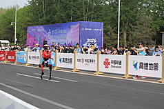 北京19日舉行「2026北京亦莊半程馬拉松暨人形機器人半程馬拉松」，許多民眾前來圍觀。圖為奔馳於賽道的一台人形機器人。