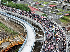 新北市府民政局25日舉辦淡江大橋通車前健行暖身活動，吸引綿延的人龍上橋，飽覽淡水河口景色。圖為空拍照片，參加健行人潮相當壯觀。