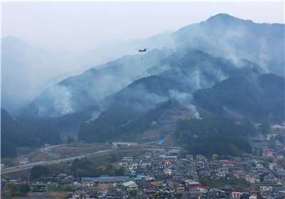 日本岩手縣大槌町(Otsuchi)野火，日本自衛隊直升機持續救援。(讀賣新聞/AFP)
