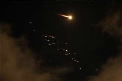 圖為以色列內坦亞(Netanya)上空8日凌晨出現火箭尾跡。