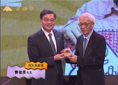 首屆金繪獎「特別貢獻獎」由深耕台灣兒童文學與繪本逾一甲子的資深創作人曹俊彥(右)獲得，並由行政院長卓榮泰(左)親自頒獎。(擷取自文化部直播網站)