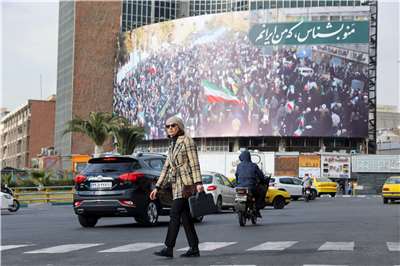 伊朗自一個多月前開始實施網路封鎖，衝擊民生生活。圖為德黑蘭民眾經過一塊寫著「認識我，我是伊朗」的廣告看板。資料照。