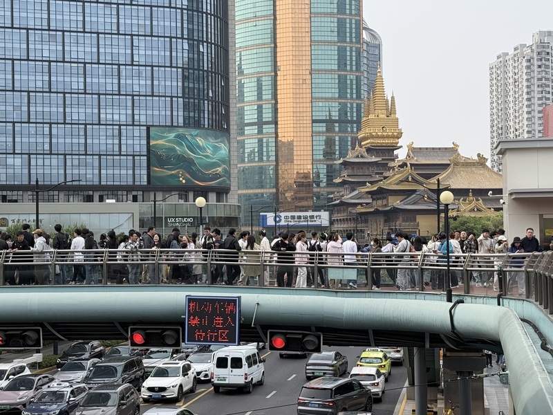 中國五一黃金周帶動出遊潮，也讓相關銷售出現兩位數成長。圖為中國五一假期，上海靜安寺附近天橋聚集拍照人潮。
