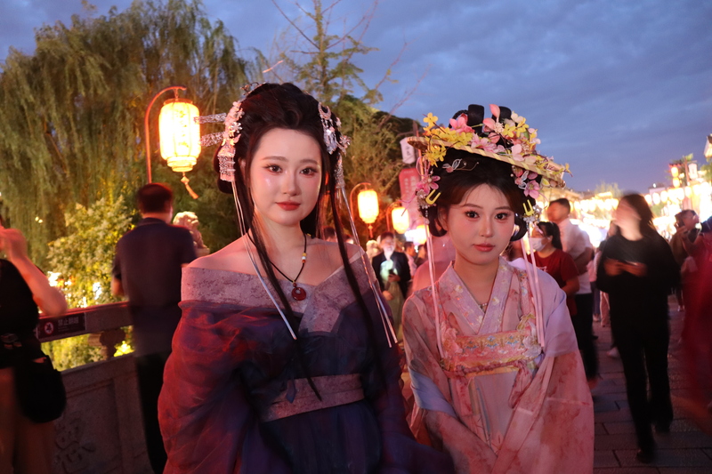 位於河南洛陽老成區的洛邑古城，許多遊客穿「漢服」到此遊逛，帶動相關產業。張小姐（左）說，自己一身行頭僅人民幣132元，包括全妝、頭飾與衣服租金，還能在一天內無限次補妝。照片攝於28日。
