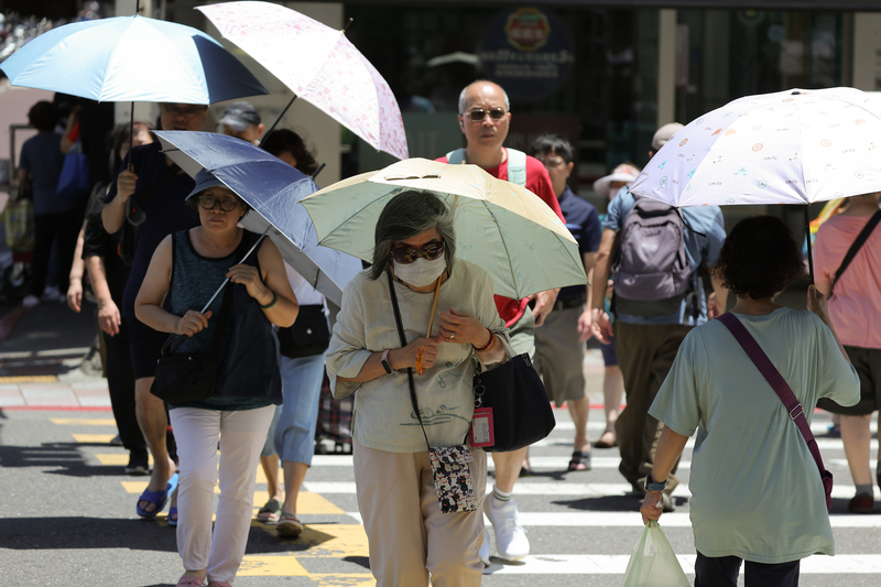 颱風薔蜜將轉中度颱風，6月1日抵達琉球北方海面，北部宜蘭等迎風面受外圍環流影響，將有零星或局部降雨。31日天氣狀況各地多雲到晴，北部及東半部高溫約攝氏29至32度。圖為台北市內湖區民眾撐傘遮陽。