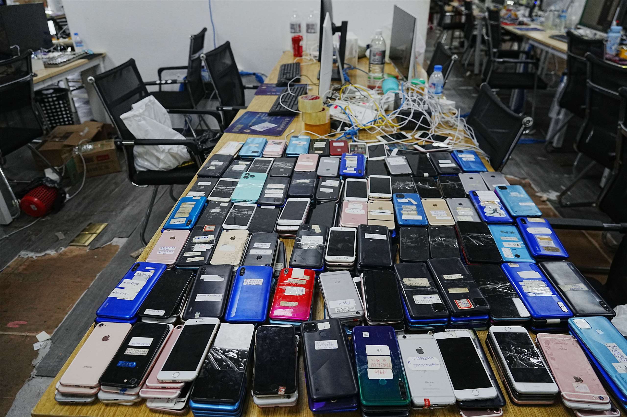 圖為柬埔寨警方在一次突擊行動中查獲的設備，陳列在金邊一處詐騙中心的桌上。資料照片。攝於2026年3月11日。