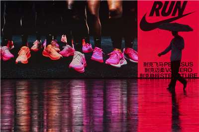 美國運動品牌Nike的中國市場曾經創下20季連續雙位數成長，如今在中國品牌安踏、李寧等快速崛起下，耐吉卻陷入單季雙位數衰退窘境。圖為一名中國男子撐傘走過北京一家耐吉商店前。(AFP)