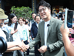 民進黨台北市長參選人沈伯洋（前右）16日前往大龍峒保安宮參香祈福，並接受媒體訪問。