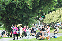 氣象署24日下午更新高溫資訊，其中雙北市為黃色燈號，需注意攝氏36度以上高溫。圖為台北花博公園午後人潮，有民眾待在樹蔭下休憩。