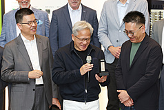 輝達執行長黃仁勳(前中)29日在南港展覽館2館出席輝達AI Factory MGX Ecosystem Ceremony，手持迷你版MGX機櫃架構。