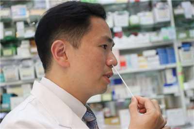 首款「三合一家用快篩」去年底核准通過，最快5月底鋪貨。圖為中華民國藥師公會全國聯合會發言人黃彥儒示範家用快篩試劑，採檢棒以旋轉方式在鼻腔採檢。(中央社資料照)