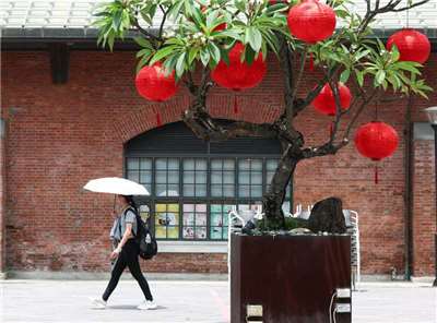 中央氣象署今天(24日)針對，北北桃等8縣市亮高溫燈號，其中，台南亮紅燈，要注意攝氏38度以上高溫。圖為台北市西門町商圈街頭民眾撐傘遮陽。 (圖：中央社)