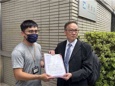 美商合泰公司委託律師郝燮戈(右)赴經濟部遞交陳情書，抗議台電核三乾貯設施採購黑箱，經濟部國營司承辦人李宗軒(左)出面收下陳情書。(謝佳興 攝)