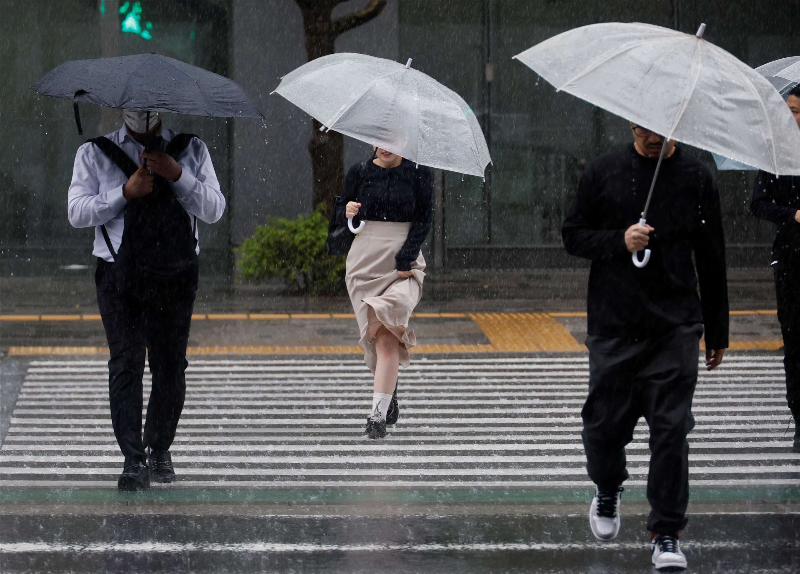 颱風「薔蜜」3日挾豪雨襲捲東京，圖為行人穿行在暴雨中。