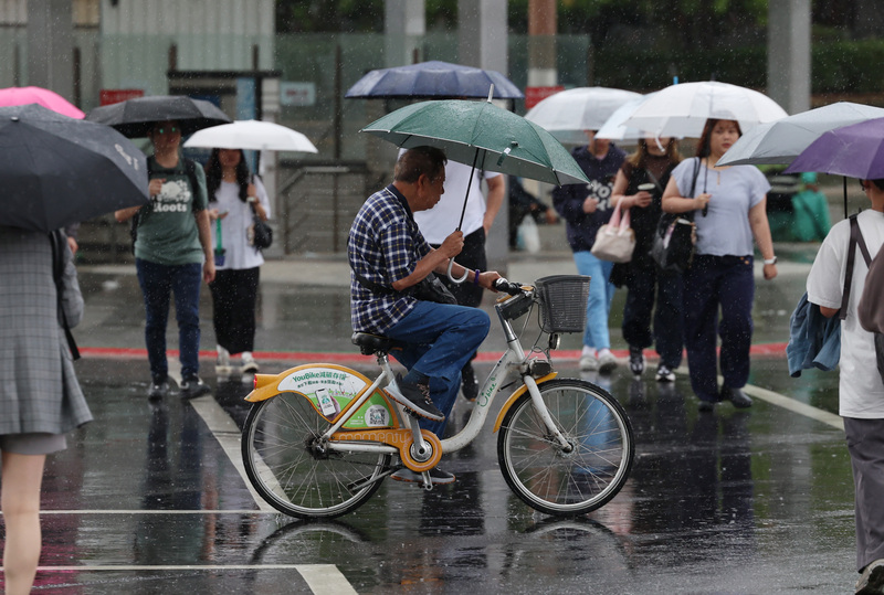 台北市5日下大雨，信義區民眾撐傘過馬路。