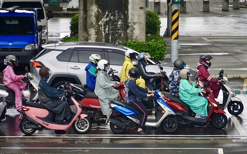 豪雨來襲，高雄機車騎士紛紛穿起雨衣，在雨中前進。資料照片。