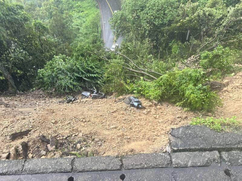 新北市新店區涵煙翠社區前路段18日下午因大雨導致土石崩落坍方，多輛機車也隨土石滑落毀損。警方已先封閉該處路段，相關單位緊急派員搶修中。（翻攝畫面）