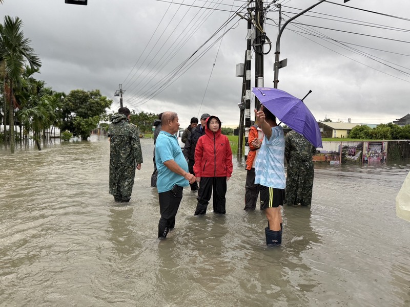 屏東縣豪大雨多處積淹水，屏東縣長周春米(紅衣者)25日於縣議會結束後，前往屏東市頂柳社區等多
處視察。（屏東縣政府提供）