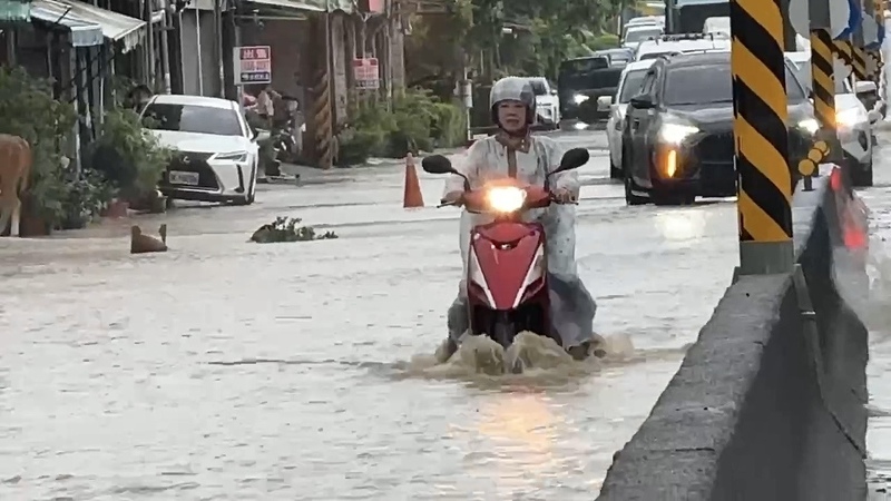 高雄市政府28日公布豪雨補助措施，住屋、營業處所淹水救助50公分以上，補助最高新台幣3.5萬元、未滿50公分1萬元；另外家電受損再補助1萬元。圖為高雄市旗山區路面積淹水，騎士經過激起水花。