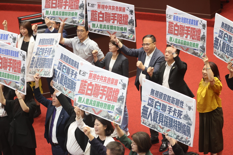 針對行政院所提國防自主無人載具採購特別條例草案，立法院會26日處理報告事項議程時，台灣民眾黨立法院黨團、國民黨立法院黨團提議暫緩列案，表決結果，藍白挾人數優勢勝出；圖為民進黨立委高舉標語指藍白聯手阻擋，扼殺台灣國防產業發展。