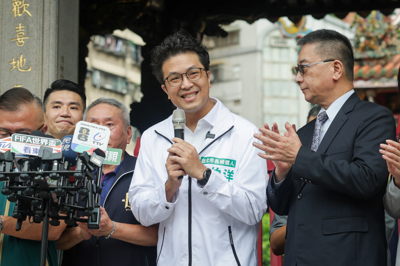 民進黨台北市長參選人沈伯洋（中）由民進黨秘書長徐國勇（右）等陪同，28日上午至龍山寺參拜，會前受訪回應內湖淹水及育兒政策等議題。