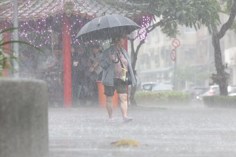 中央氣象署28日下午針對北北基發布大雷雨即時訊息，慎防短延時強降雨、閃電落電。圖為台北市大安區出現午後雷陣雨，民眾撐傘擋雨。