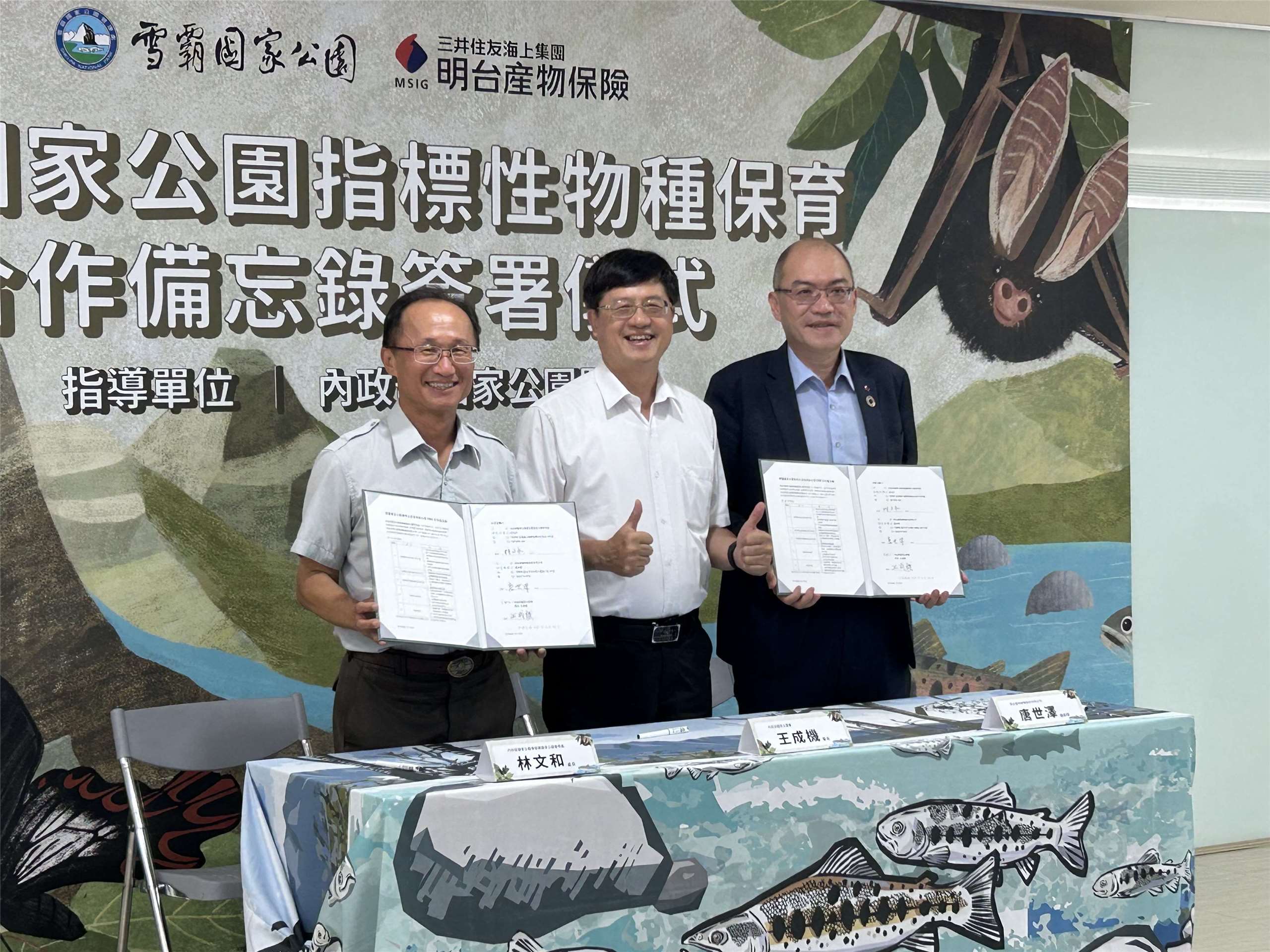 內政部國家公園署雪霸國家公園管理處處長林文和(左)今天(22日)與明台產物保險股份有限公司總經理唐世澤(右)在國家公園署長王成機(中)見證下簽署「雪霸國家公園指標性物種保育」合作備忘錄(MOU)。（趙婉淳 攝）