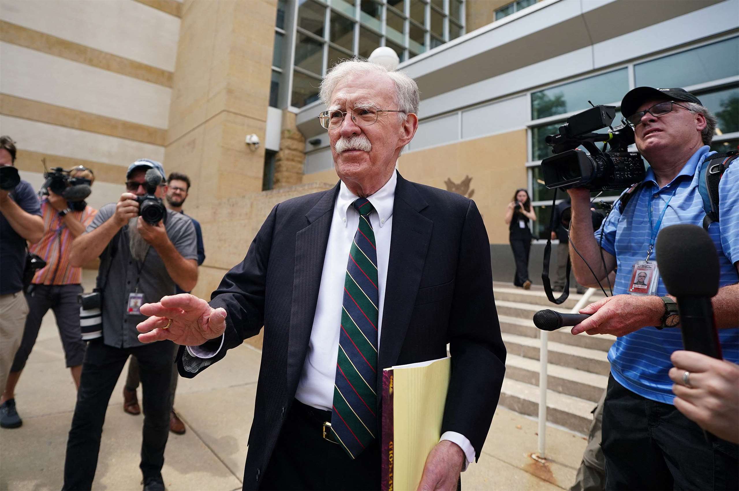 美國前國家安全顧問波頓(John Bolton)（中）在馬里蘭州地方法院參加完認罪協議庭訊後離開法院。