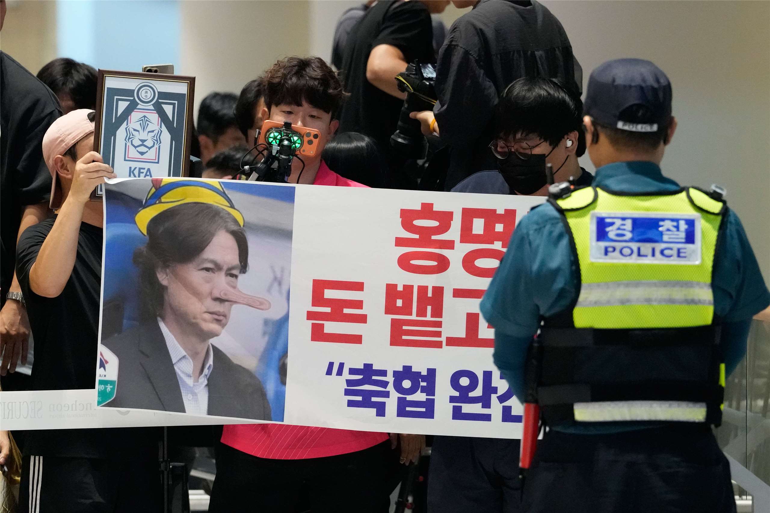 在世界盃失利的韓國隊30日返抵仁川國際機場，一名球迷手持抗議標語，要求國家隊總教練洪明甫退出足壇，並解散足協。