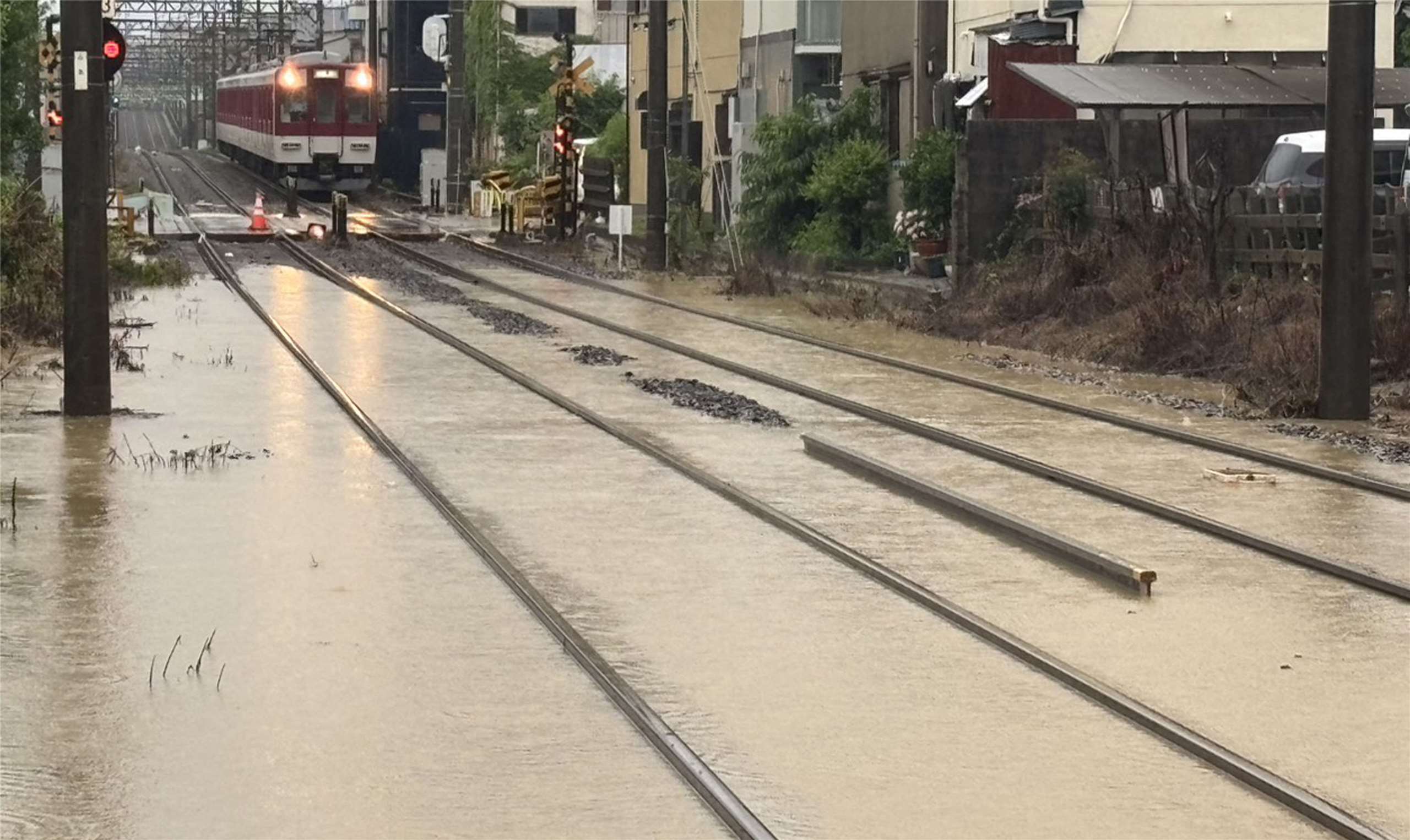 由颱風減弱為熱帶風暴的「米克拉」(Mekkhala)帶來豪雨襲擊日本南部及西部多處地區。圖為奈良生駒站附近鐵軌遭大雨淹沒。(AFP)