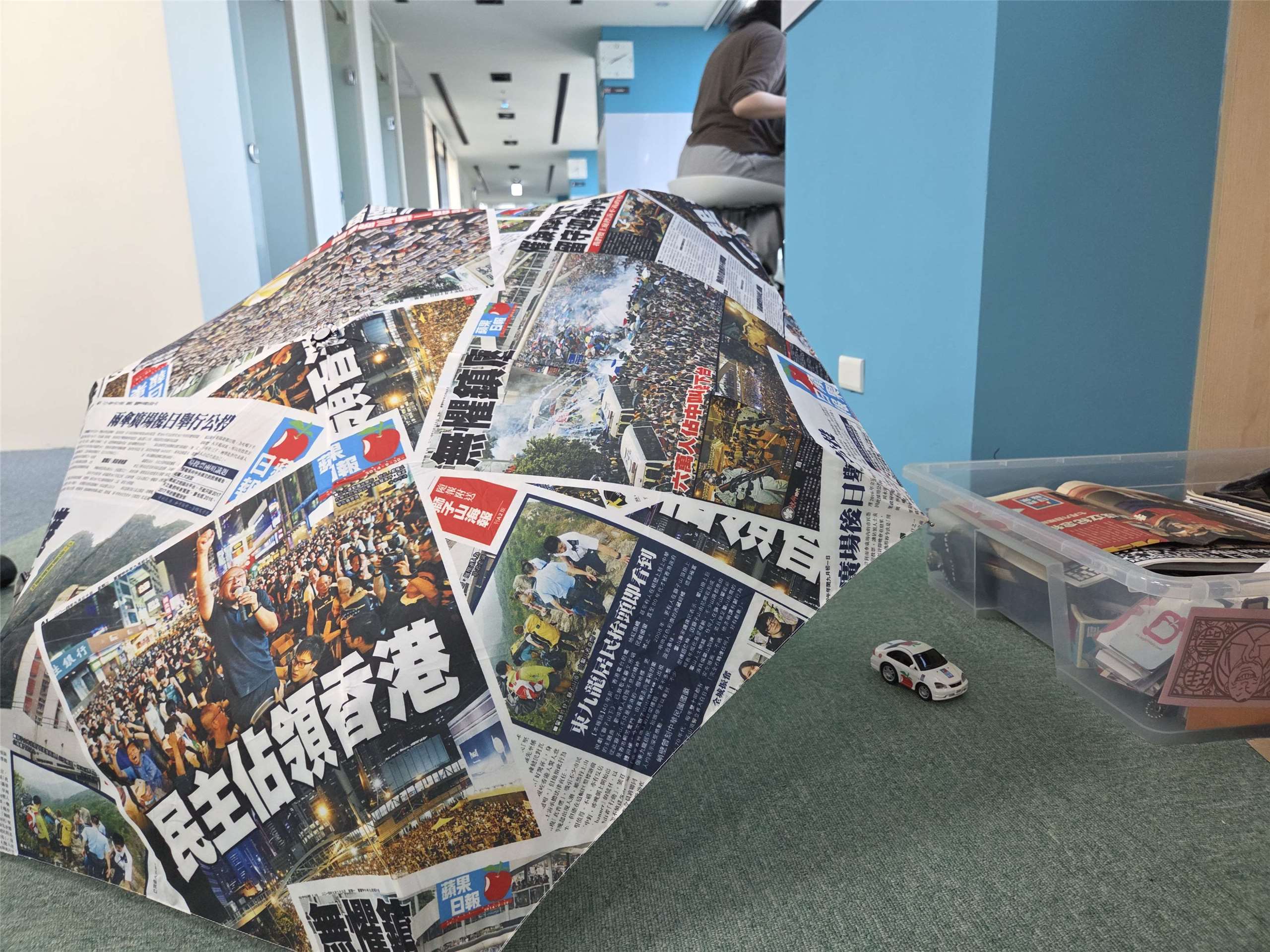 部分展品，分別為印製《蘋果日報》的雨傘及採訪車模型。(饒辰書 攝)