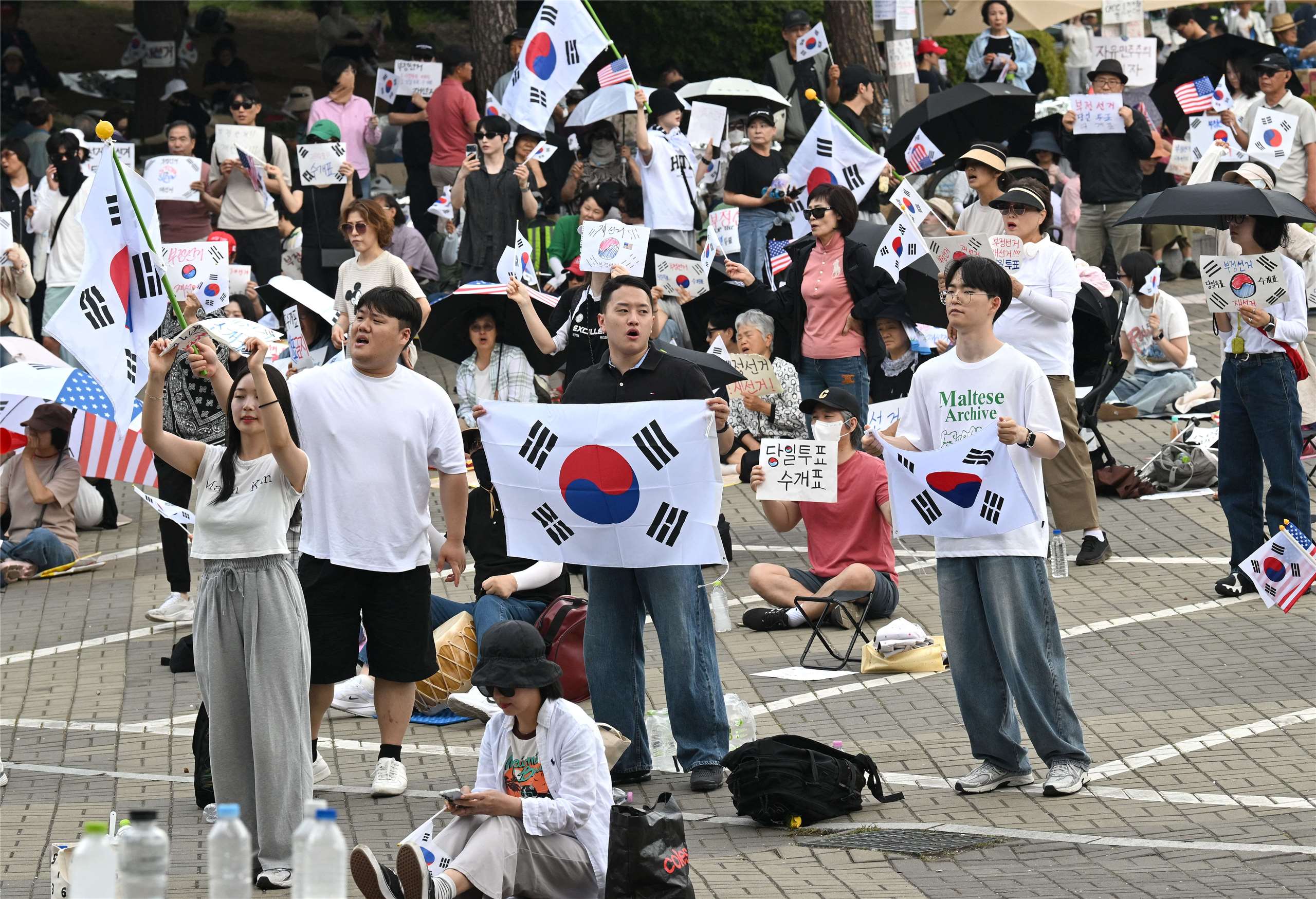 韓國示威者10日抗議地方選舉選票短缺，在首爾一處計票中心外揮舞國旗，要求重新選舉。