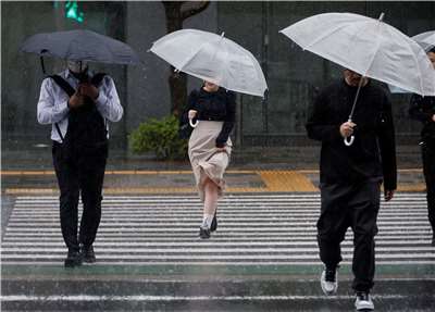 颱風「薔蜜」3日挾豪雨襲捲東京，圖為行人穿行在暴雨中。
