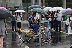 台北市5日下大雨，信義區民眾撐傘過馬路。