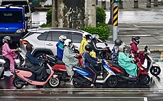交通部中央氣象署8日發布豪雨特報，鋒面接近、西南風增強及午後對流雲系發展旺盛，易有短延時強降雨，高雄市前鎮區午後出現雨勢，機車騎士紛紛穿起雨衣。
