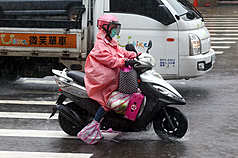 天氣不穩定，新北土城騎士穿雨衣，並用塑膠袋包著鞋子防止雨水浸濕。資料照片。