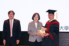 前總統蔡英文（中）13日出席高雄醫學大學畢業典禮，校長余明隆（右）致贈繡有「YBSG」的高醫大
畢業熊。