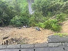 新北市新店區涵煙翠社區前路段18日下午因大雨導致土石崩落坍方，多輛機車也隨土石滑落毀損。警方已先封閉該處路段，相關單位緊急派員搶修中。（翻攝畫面）