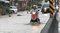 高雄市政府28日公布豪雨補助措施，住屋、營業處所淹水救助50公分以上，補助最高新台幣3.5萬元、未滿50公分1萬元；另外家電受損再補助1萬元。圖為高雄市旗山區路面積淹水，騎士經過激起水花。