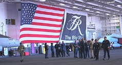 美軍羅斯福號航空母艦停靠珍珠港，參與2026年第30屆環太平洋軍演，機庫甲板懸掛大型美國國旗、旗幟寫著船艦外號「大棒」（The Big Stick）。