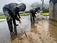 國軍第四作戰區官兵26日清除道路積淤，確保排水系統暢通，降低二次淹水風險。（第四作戰區提供）