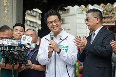 民進黨台北市長參選人沈伯洋（中）由民進黨秘書長徐國勇（右）等陪同，28日上午至龍山寺參拜，會前受訪回應內湖淹水及育兒政策等議題。