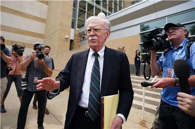 美國前國家安全顧問波頓(John Bolton)（中）在馬里蘭州地方法院參加完認罪協議庭訊後離開法院。