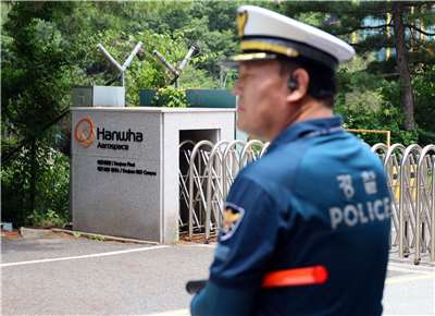 南韓韓華航太位於大田市的工廠發生火災，造成5死2傷，爆炸原因仍在調查中。圖為一名警員在工廠正門前維持秩序。