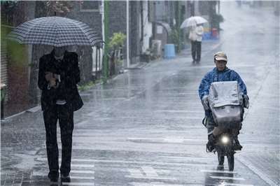 朝日電視台報導，「薔蜜」3日沿著日本列島向東推進，是14年來首次有颱風在6月登陸日本。圖為東京路上的行人。(AFP)