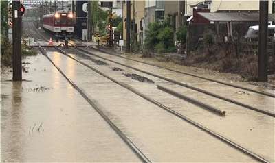 由颱風減弱為熱帶風暴的「米克拉」(Mekkhala)帶來豪雨襲擊日本南部及西部多處地區。圖為奈良生駒站附近鐵軌遭大雨淹沒。(AFP)