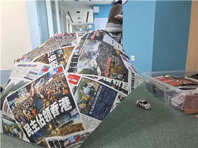 部分展品，分別為印製《蘋果日報》的雨傘及採訪車模型。(饒辰書 攝)