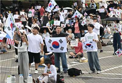 抗議地方選舉選票短缺，韓國示威者10日在首爾一處計票中心外揮舞國旗，要求重新選舉。