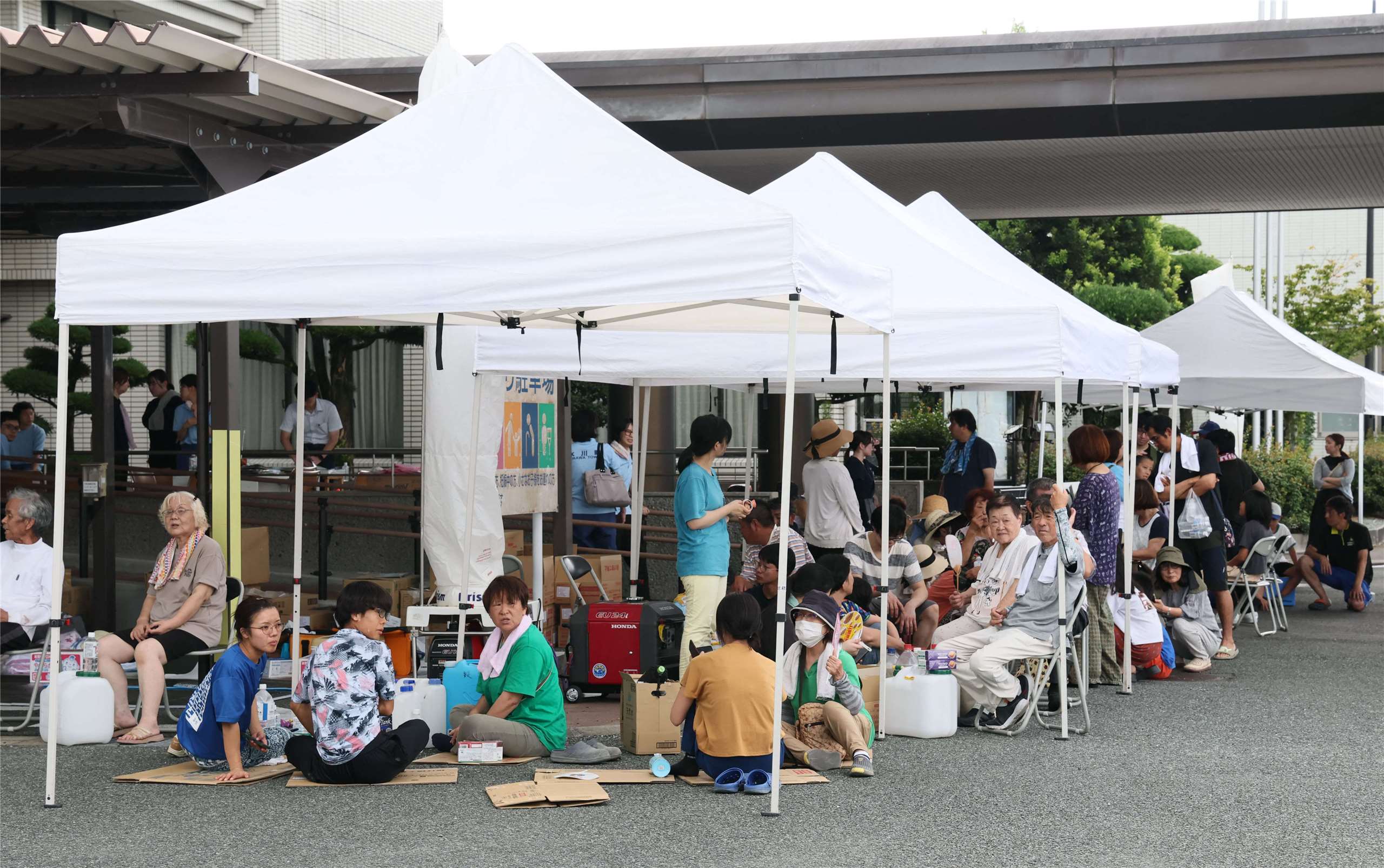日本熊本28日發生7.1強震，熊本縣冰川町居民排隊領取日本自衛隊提供的供水援助。(AFP)